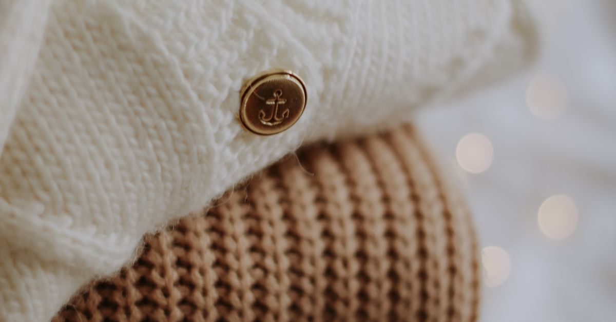 Pet play and puppy play beginner guide - stack of folded knitted blankets in warm neutral tones