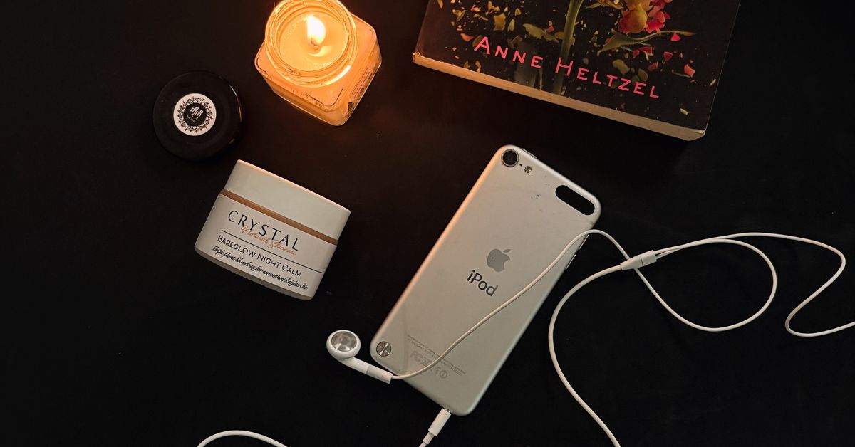 Guided masturbation setup — candle, audio player, and book in a calm still life (Red Pleasures guide)