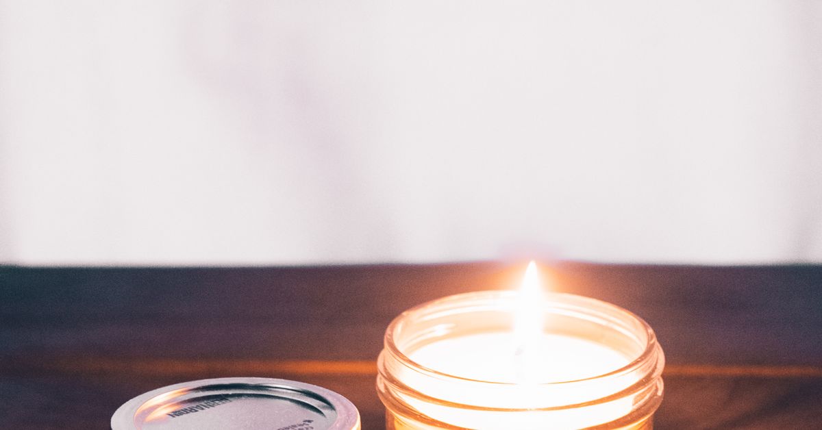 Lit candle in a glass jar on rustic wood — Nexus prostate massager guide for Canada