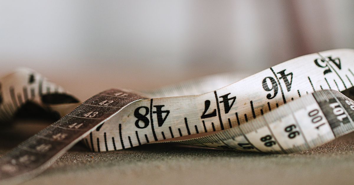 Spreader bar sex guide - close-up of a measuring tape, sizing and safety from Red Pleasures