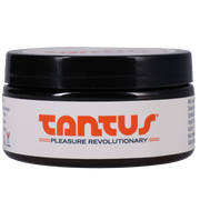 Tantus leather scented spanking cream in a black jar with a white label.
