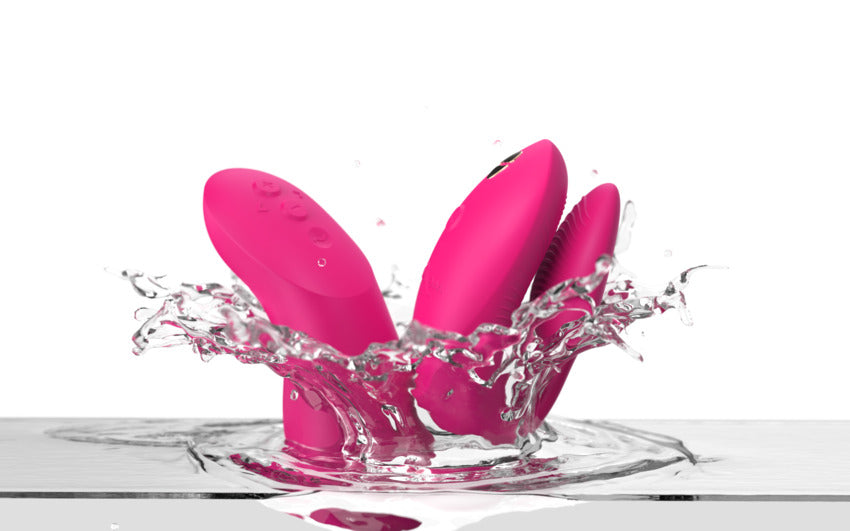 Pink Chorus Pro couples vibrator splashing in water.