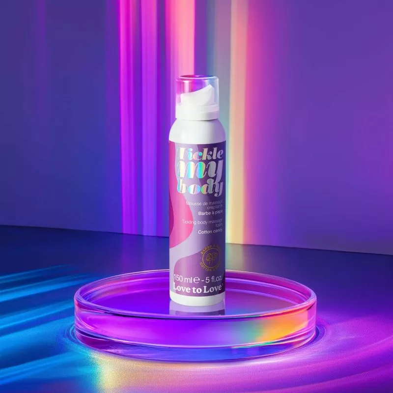 A bottle of Love to Love Cotton Candy Tickling Massage Foam on a glass dish.