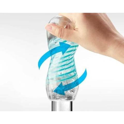Hand twisting a clear reusable male masturbator with blue spiral arrows.