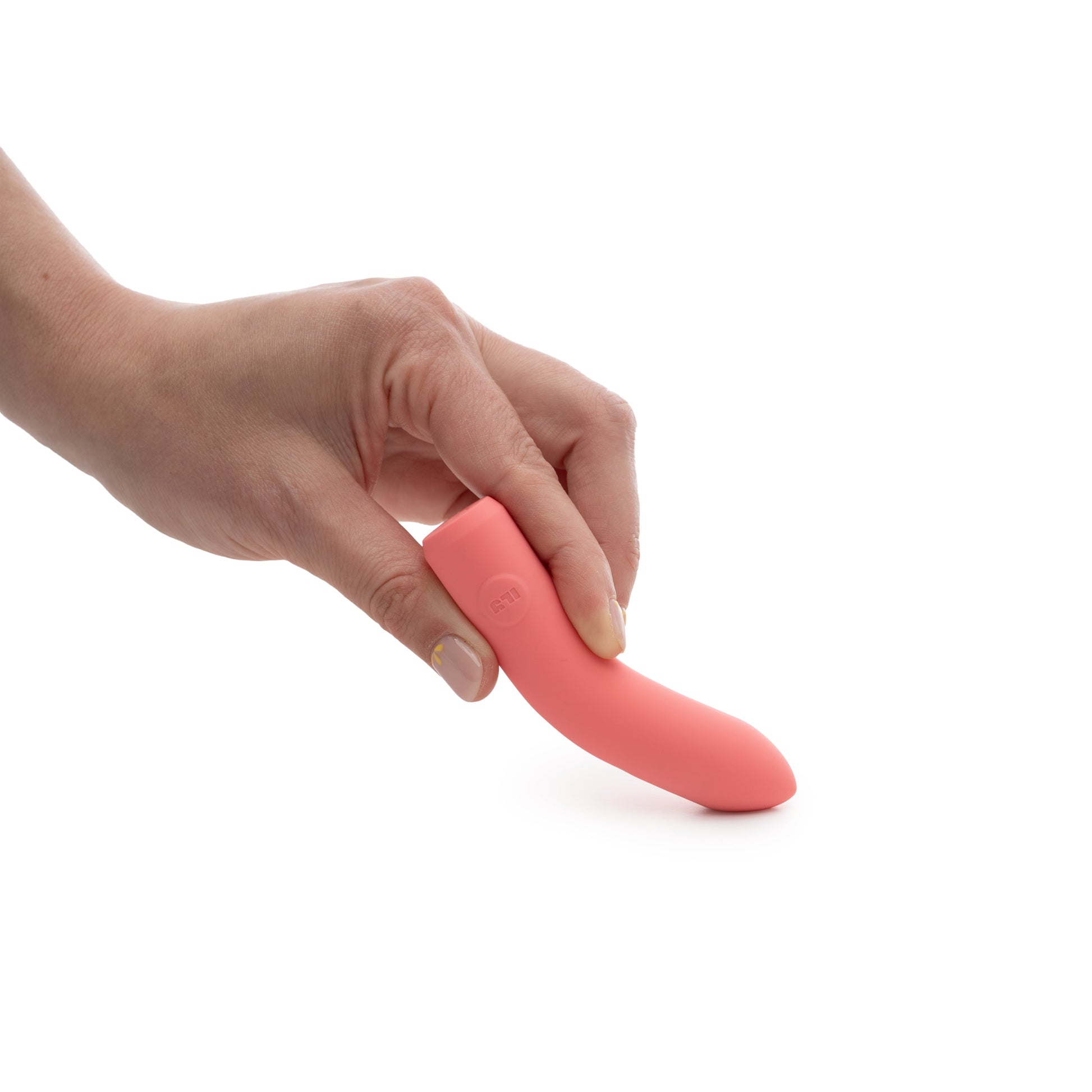 A hand holds a coral-colored vibrator with a subtle logo.