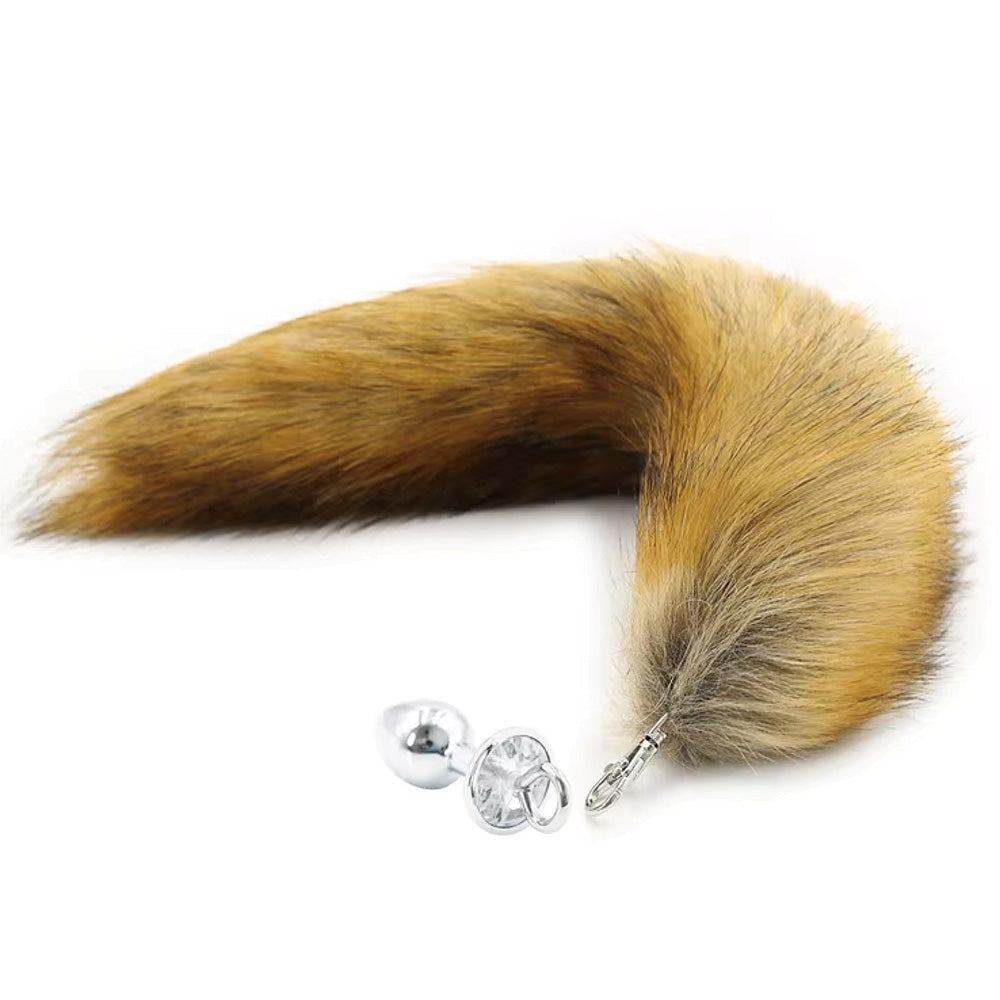 Brown faux fox tail anal plug with a silver base and clear gem.