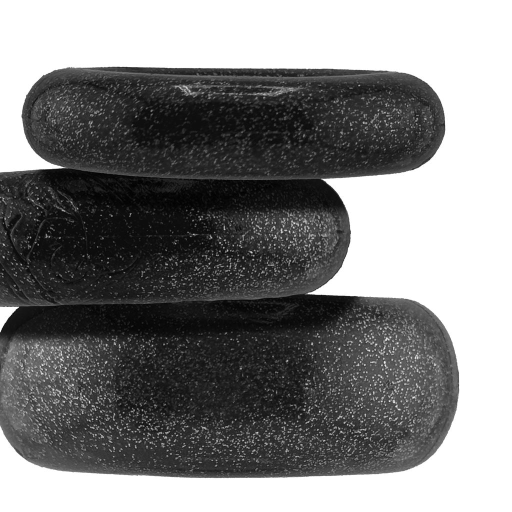 Three black mica cock rings of varying sizes stacked on top of each other.
