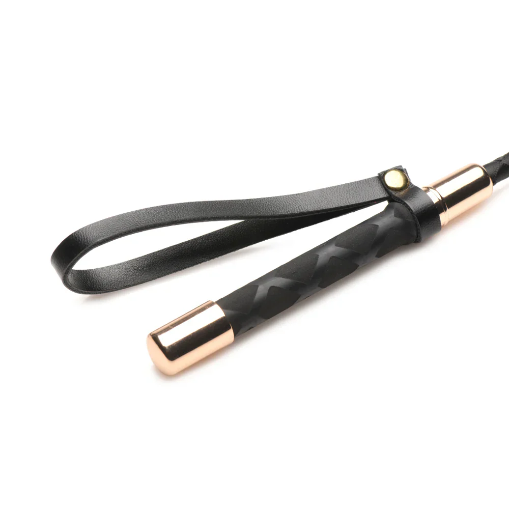 Black vegan leather riding crop with a textured grip and gold accents.