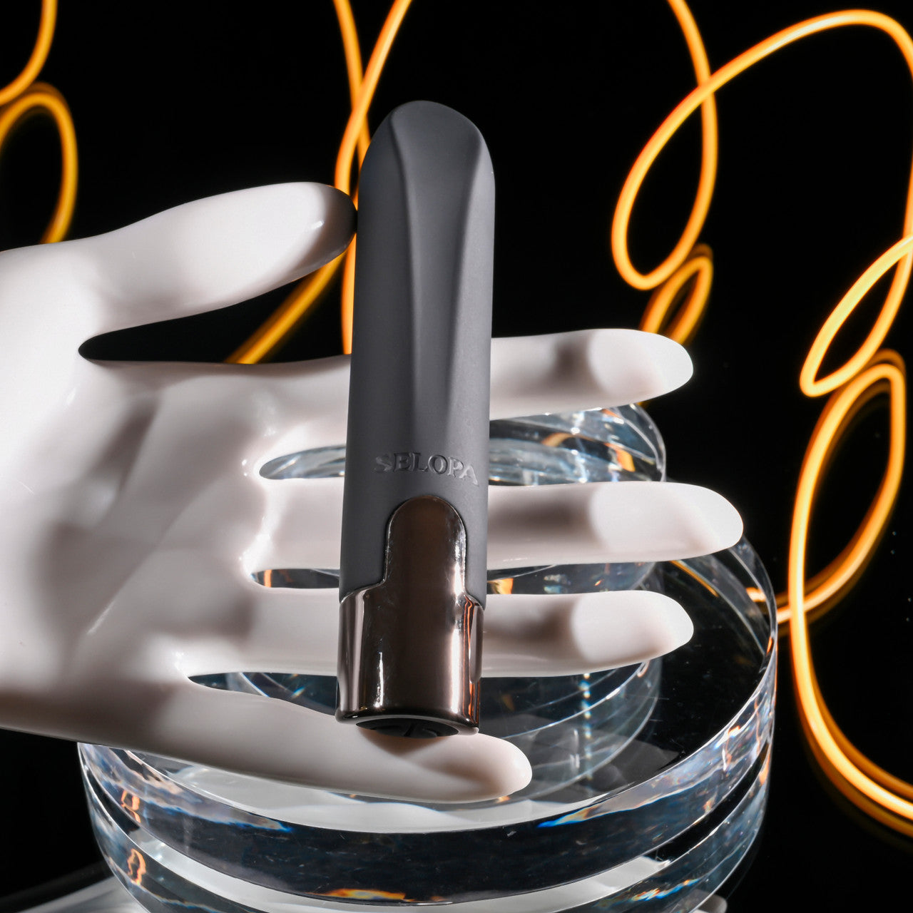 A grey SELOPA bullet vibrator held by a white mannequin hand.