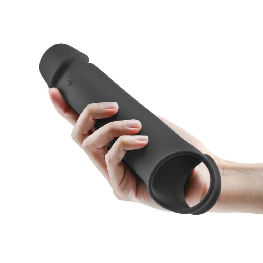 Black silicone vibrating extension sleeve held in a hand.