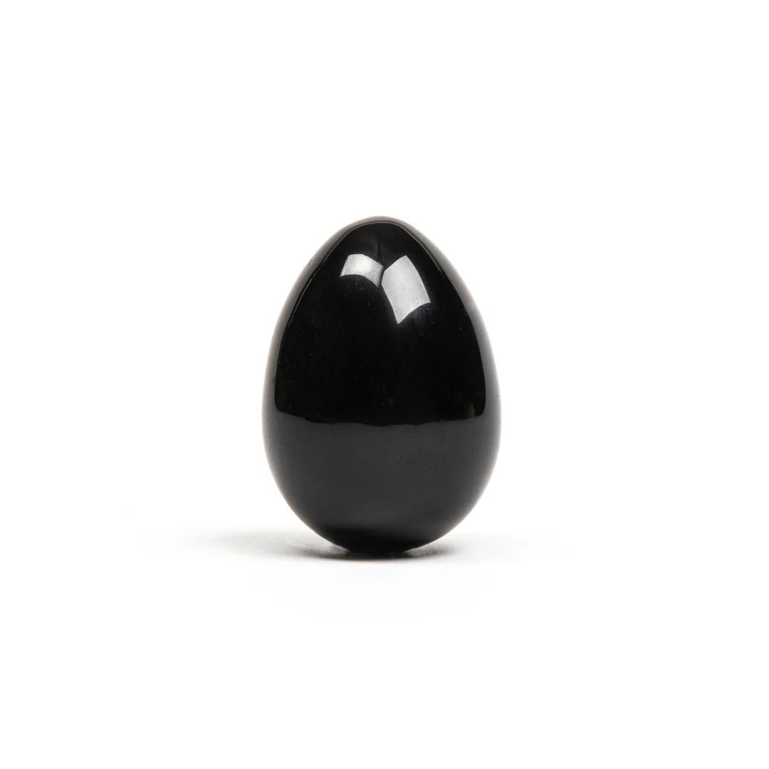 A polished black obsidian egg with a hole for string.