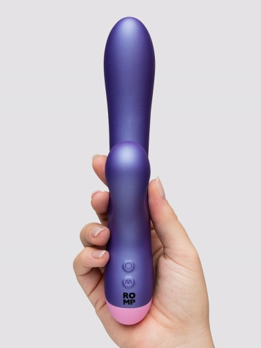 Purple rabbit vibrator with pink tip held in a hand.