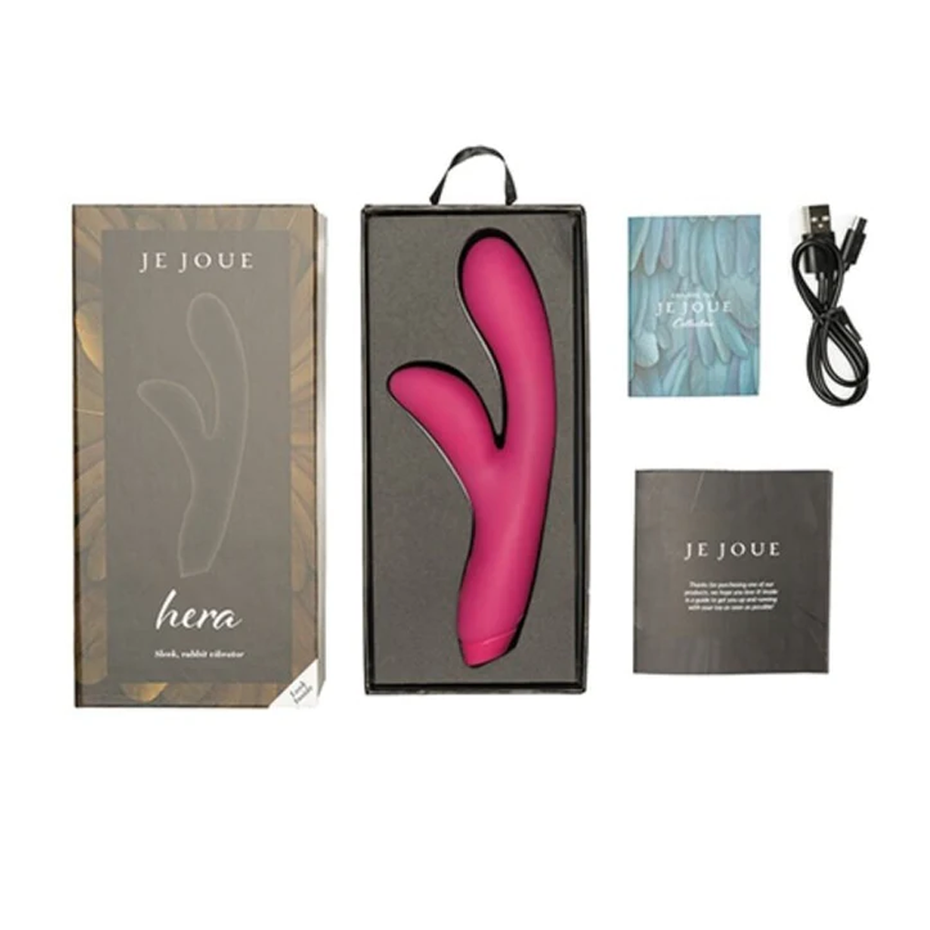 A pink rabbit vibrator with a charging cable and instruction manuals in its packaging.