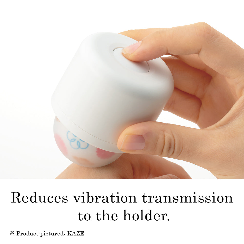 A hand holds a white personal massager with a patterned ball.
