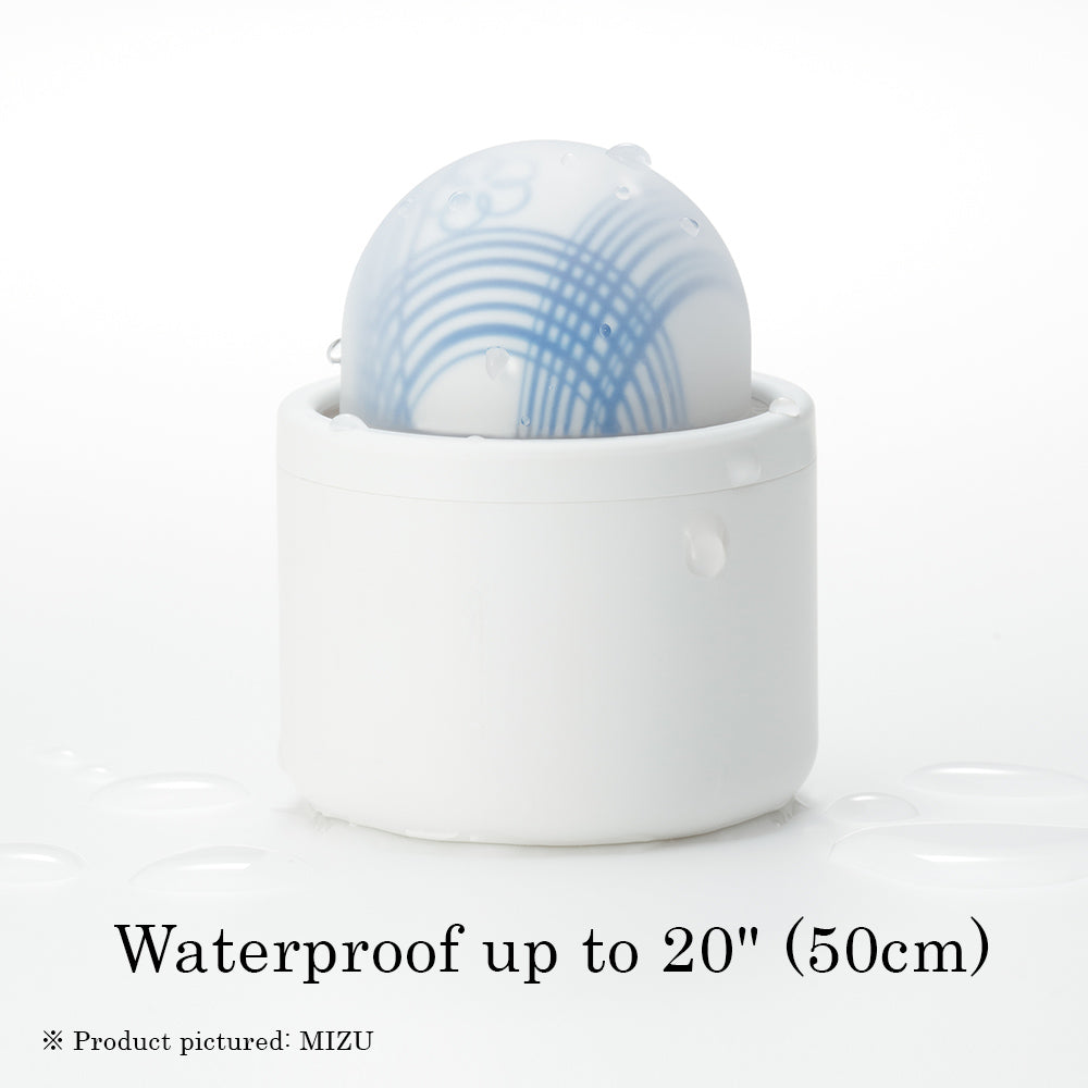 A white cylindrical base holds a translucent, dome-shaped massager with blue lines and water droplets.