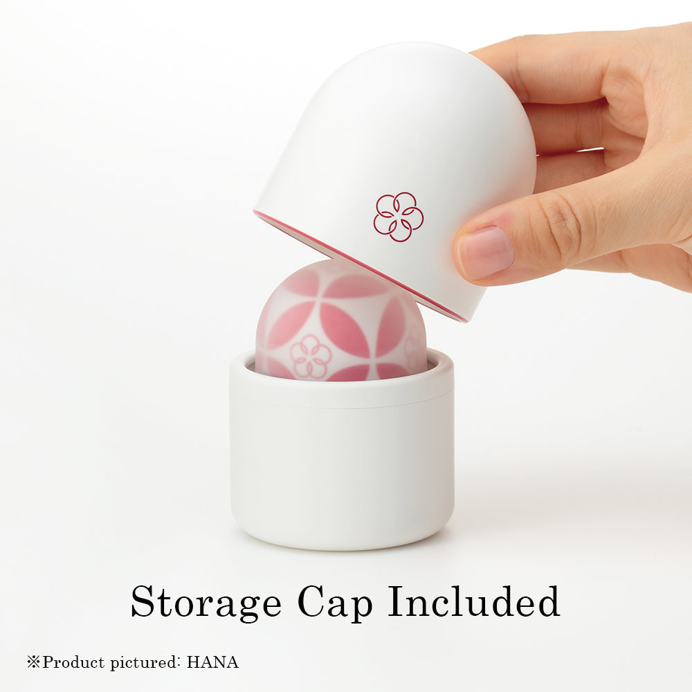 White storage cap with red floral design over a pink patterned massager.