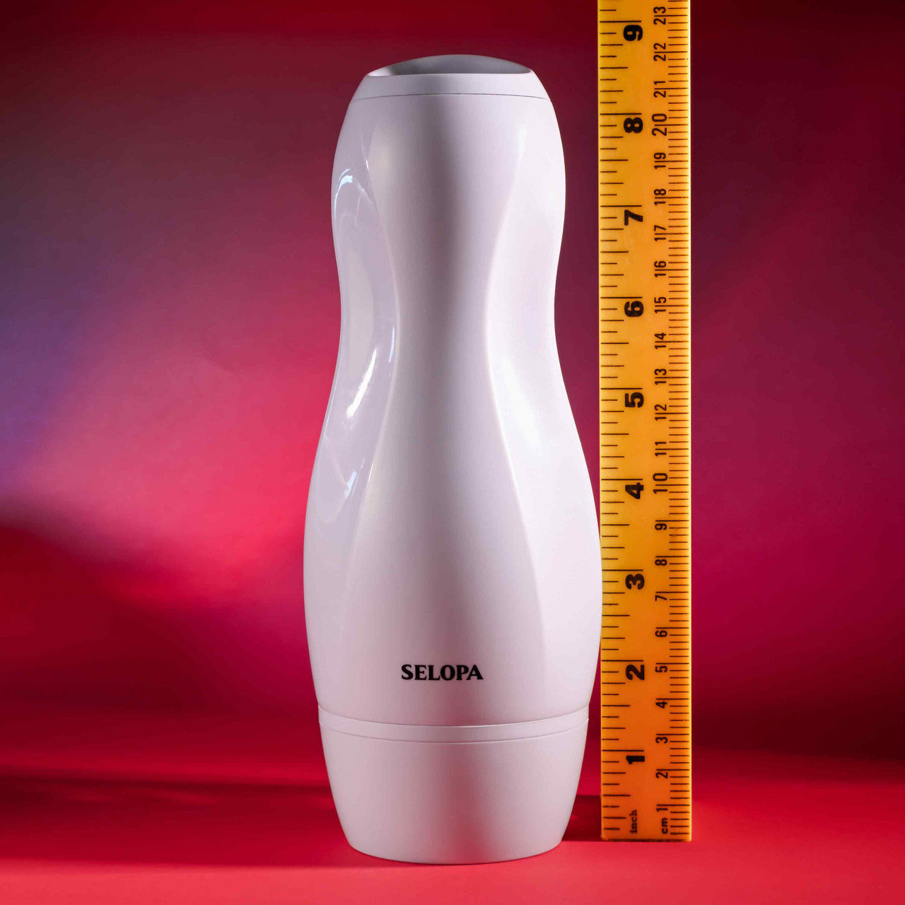 A white Selopa vibrating vaginal stroker is shown next to a ruler.