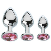 Three silver anal plugs with pink gems in graduated sizes.