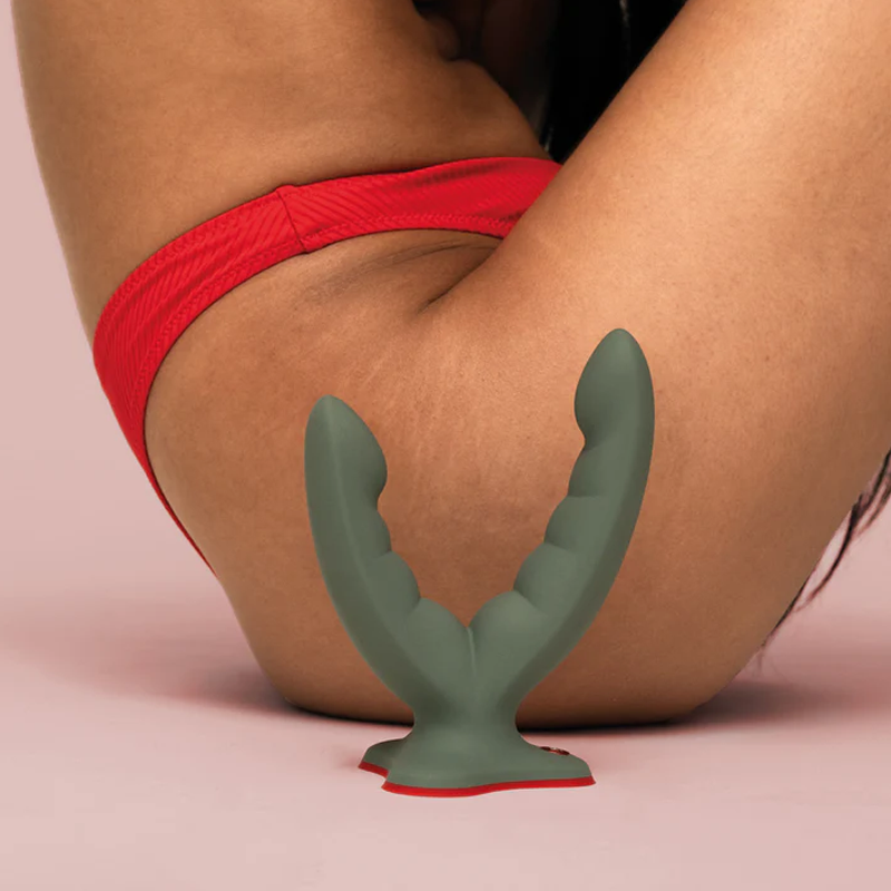 A grey dual stimulation toy with ridged ends and a red base.