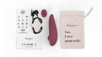 Womanizer Classic 2 clitoral stimulator in bordeaux with accessories and storage bag.