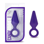 A purple medium silicone anal plug with a ring, shown in packaging and alone.
