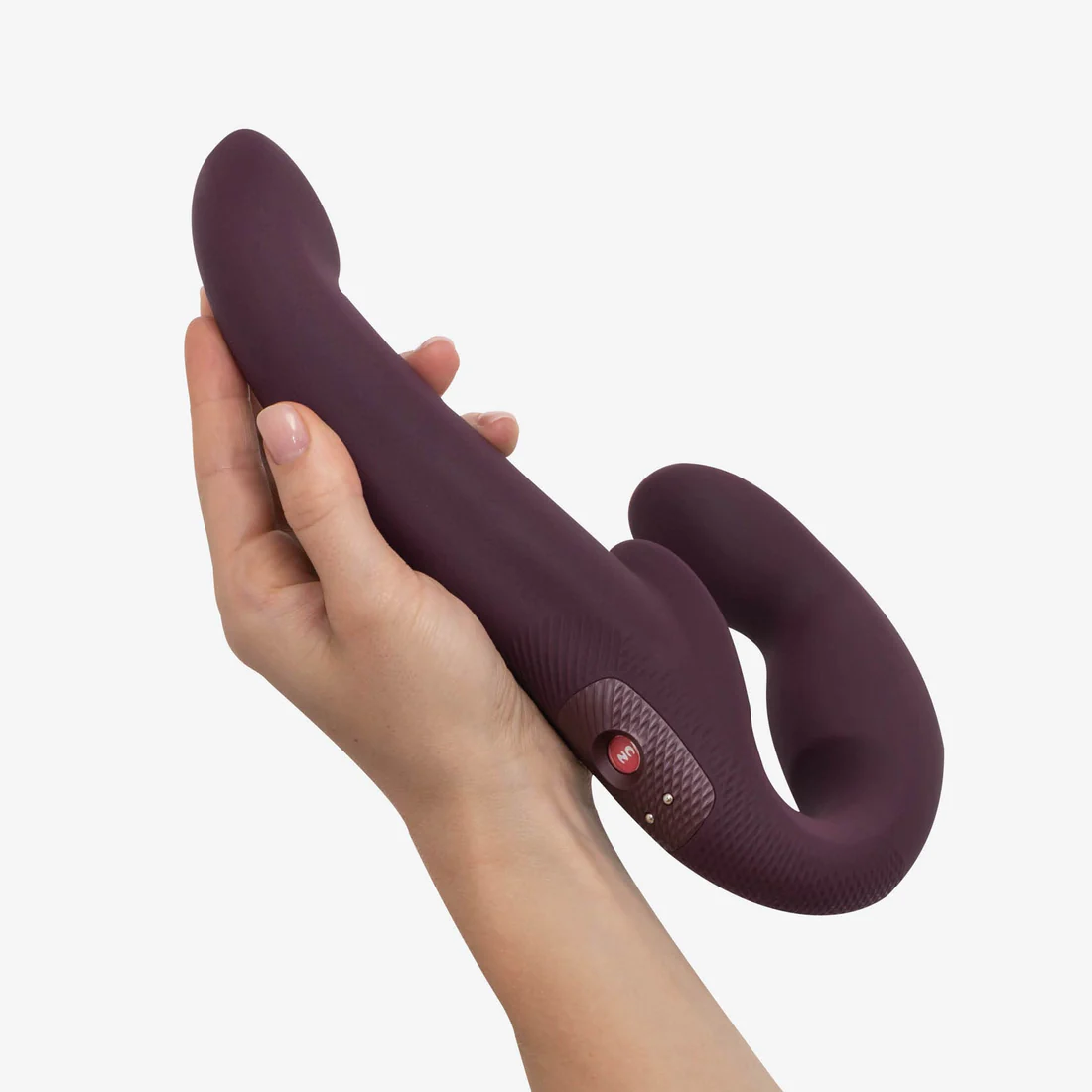 A purple dual-stimulating vibrator held in a hand.