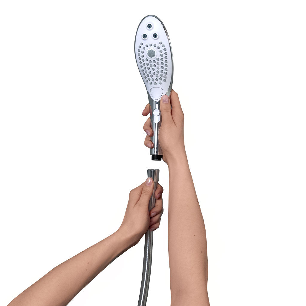 Hands connect a silver shower head with multiple spray holes to a flexible hose.