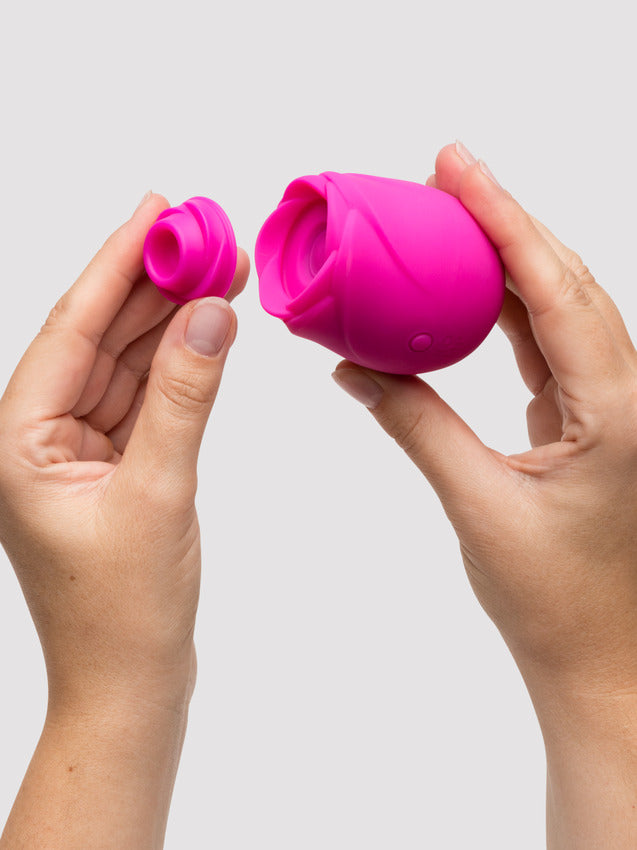 A pink rose-shaped clitoral stimulator with a detachable cap.