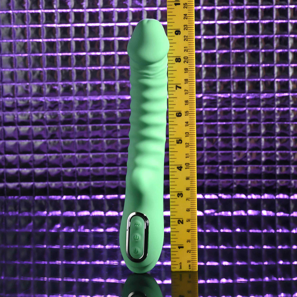 A green ribbed vibrator with a ruler showing its length.