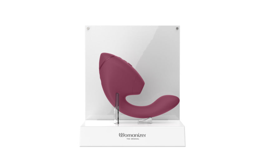 A dusky pink Womanizer dual stimulator on a white display stand.