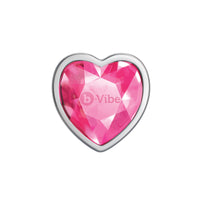 A heart-shaped pink jewel with a silver metal rim.