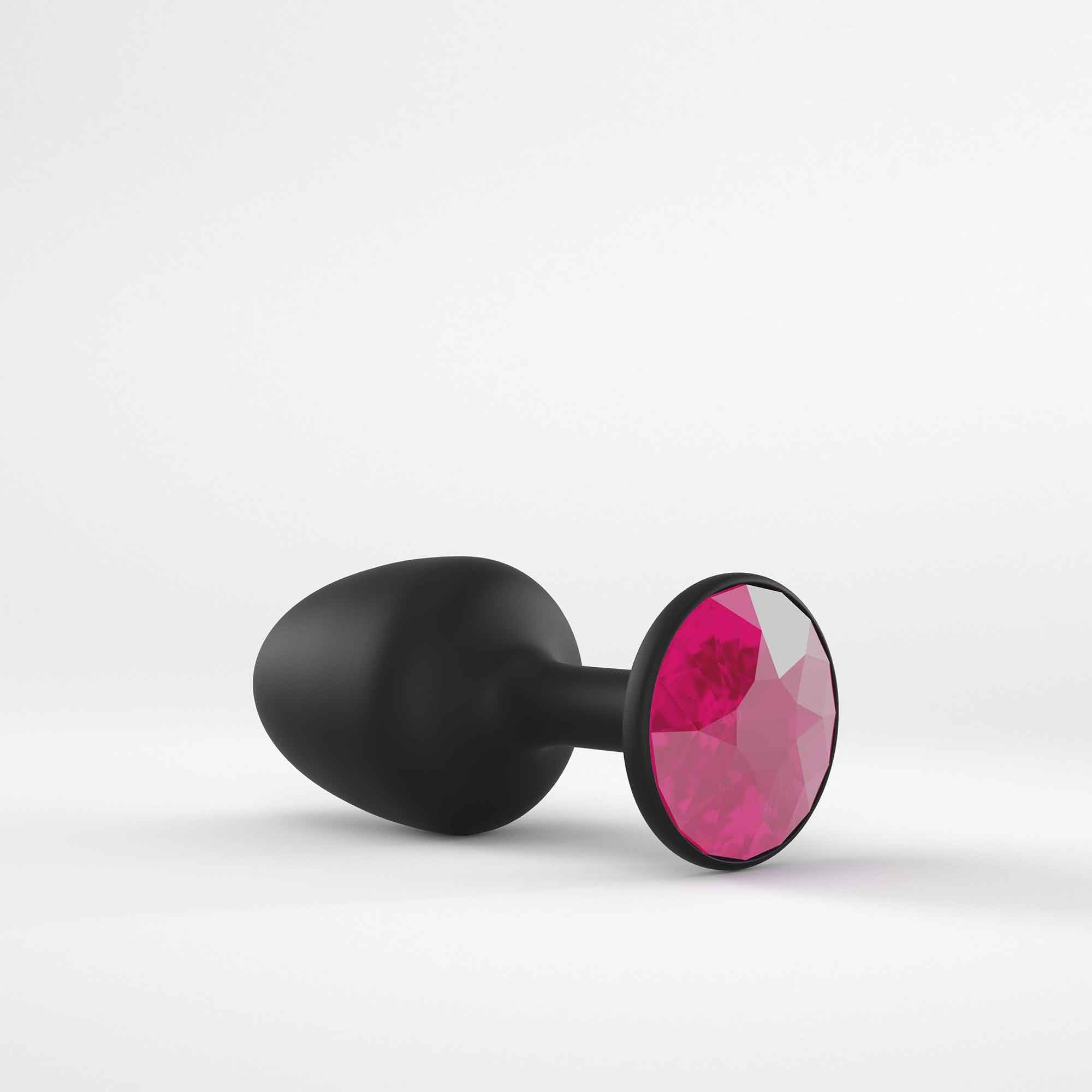 Black anal plug with a faceted ruby gem accent.