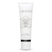 A white tube of Le Wand Coconut Love Oil personal lubricant with an orchid design.