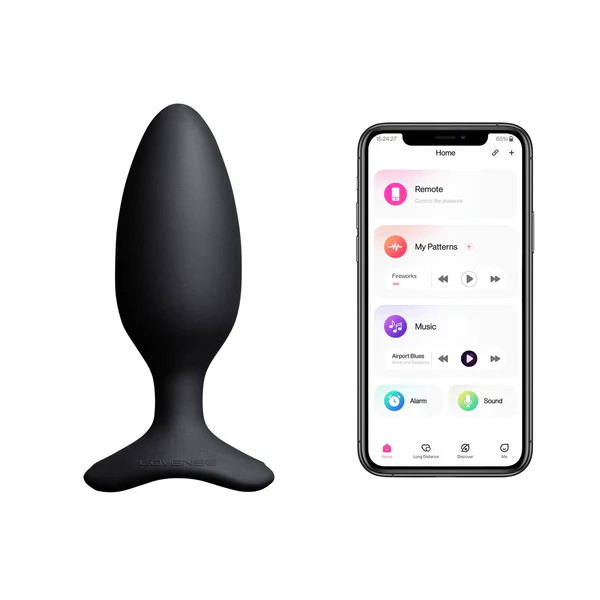 A black vibrating butt plug with a flared base, shown next to a smartphone displaying the Lovense app.