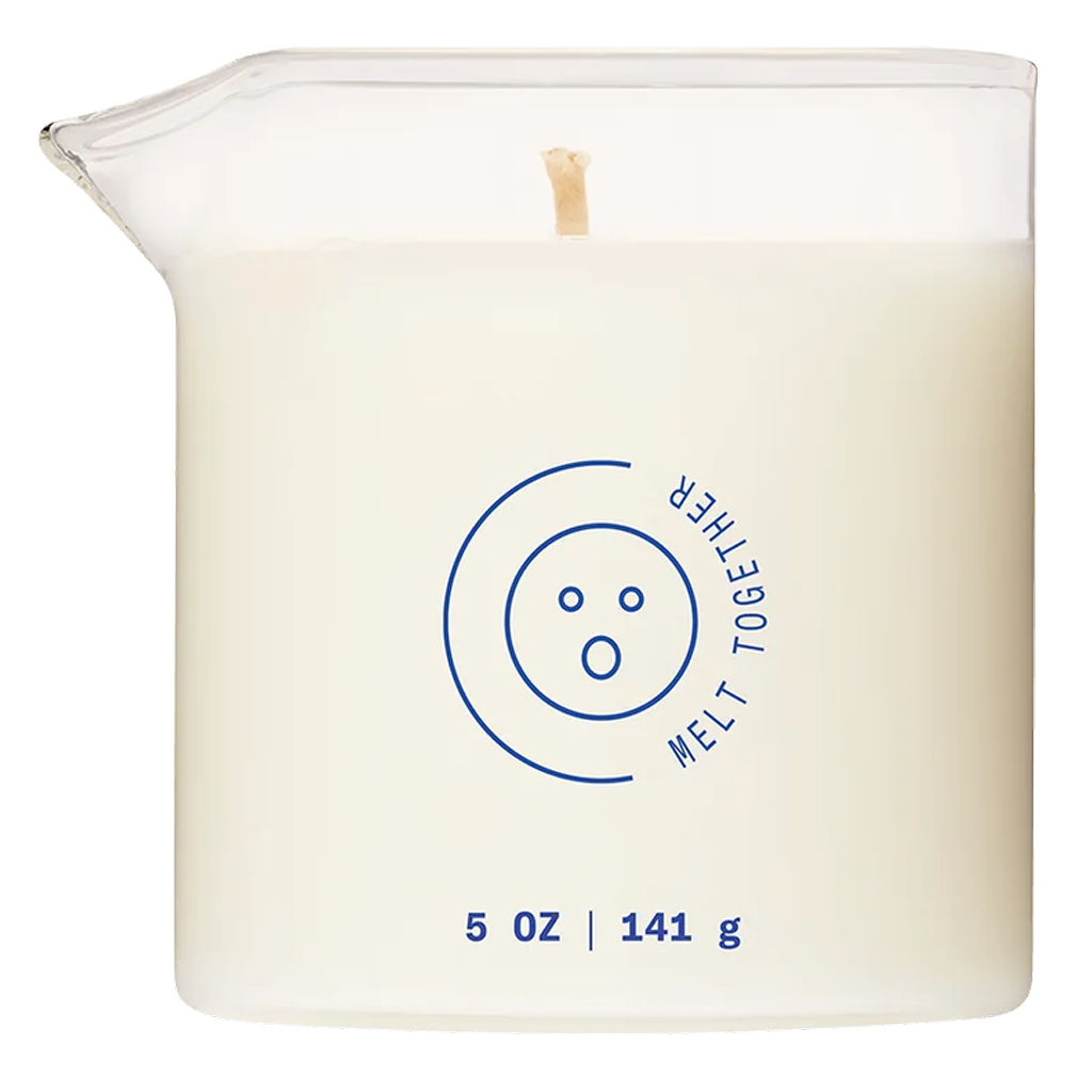 A white candle in a glass container with a pouring spout, featuring a blue circular logo and text.