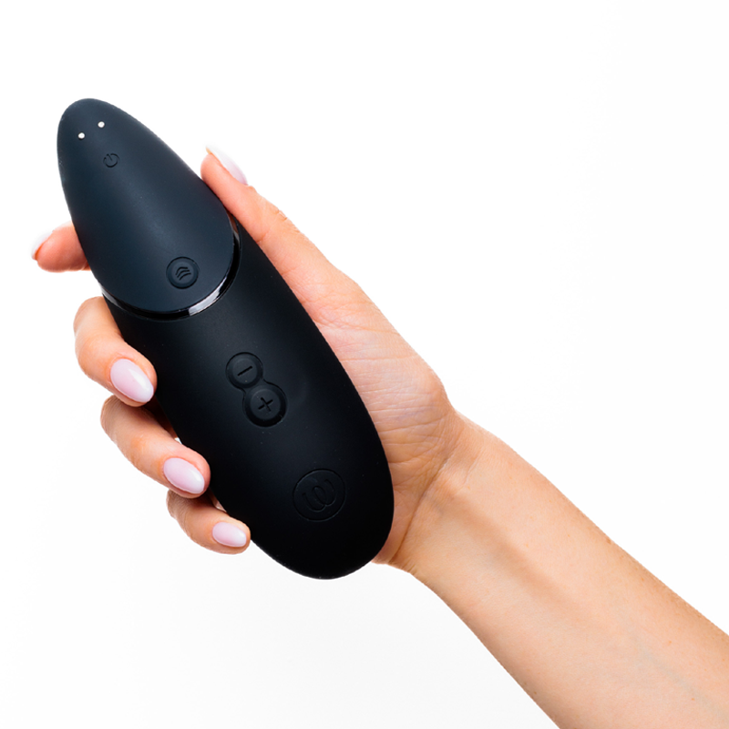 A black vibrator with buttons held in a hand.