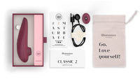 Womanizer Classic 2 clitoral stimulator in bordeaux with accessories.