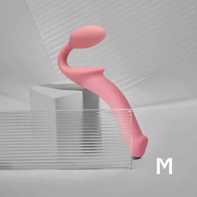 Pink bendable silicone strap-on with a curved shape.