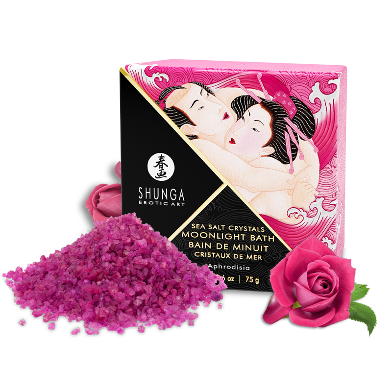 Pink sea salt crystals in a pile next to a box with an erotic art design and a pink rose.