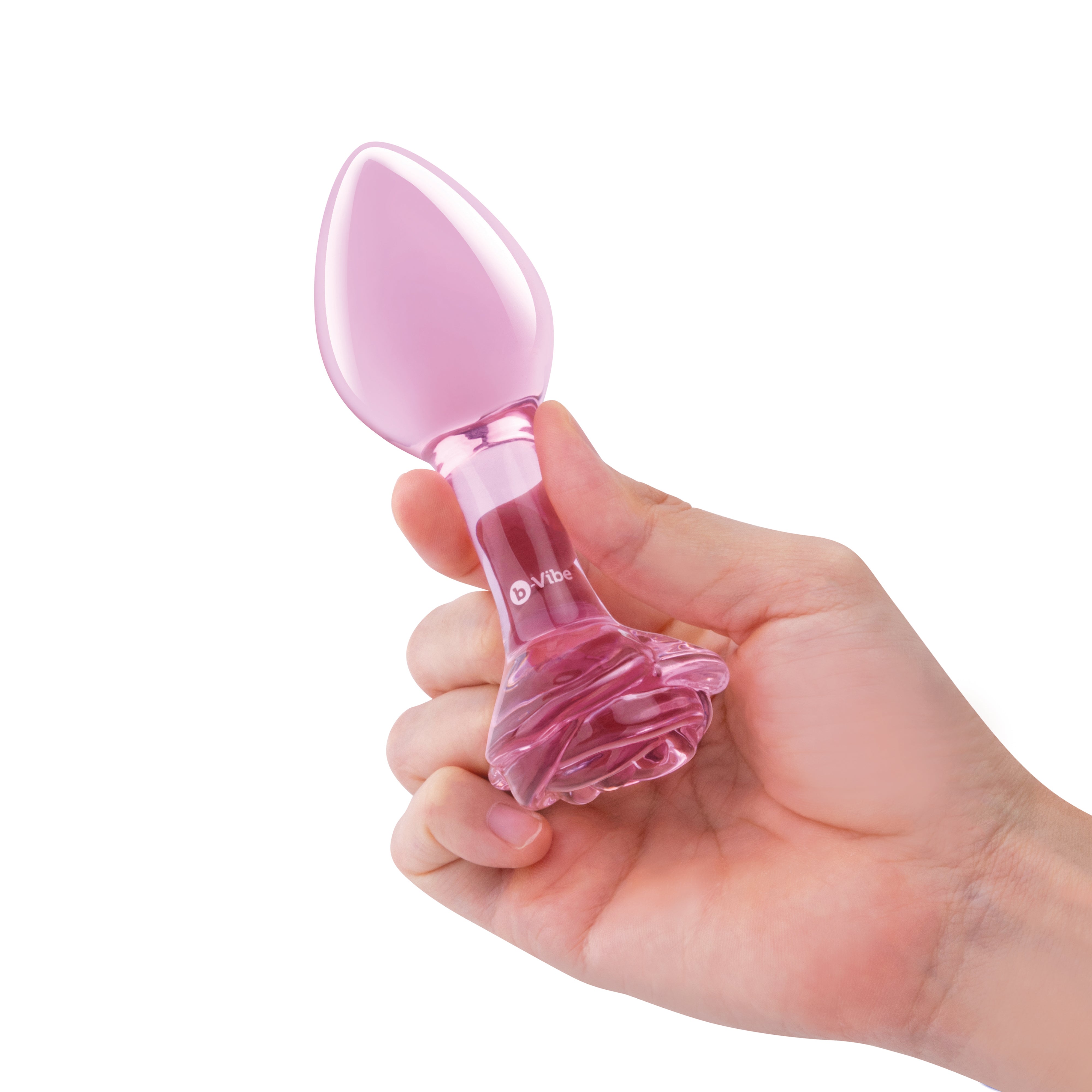 A hand holds a pink glass anal plug with a rose-shaped base.
