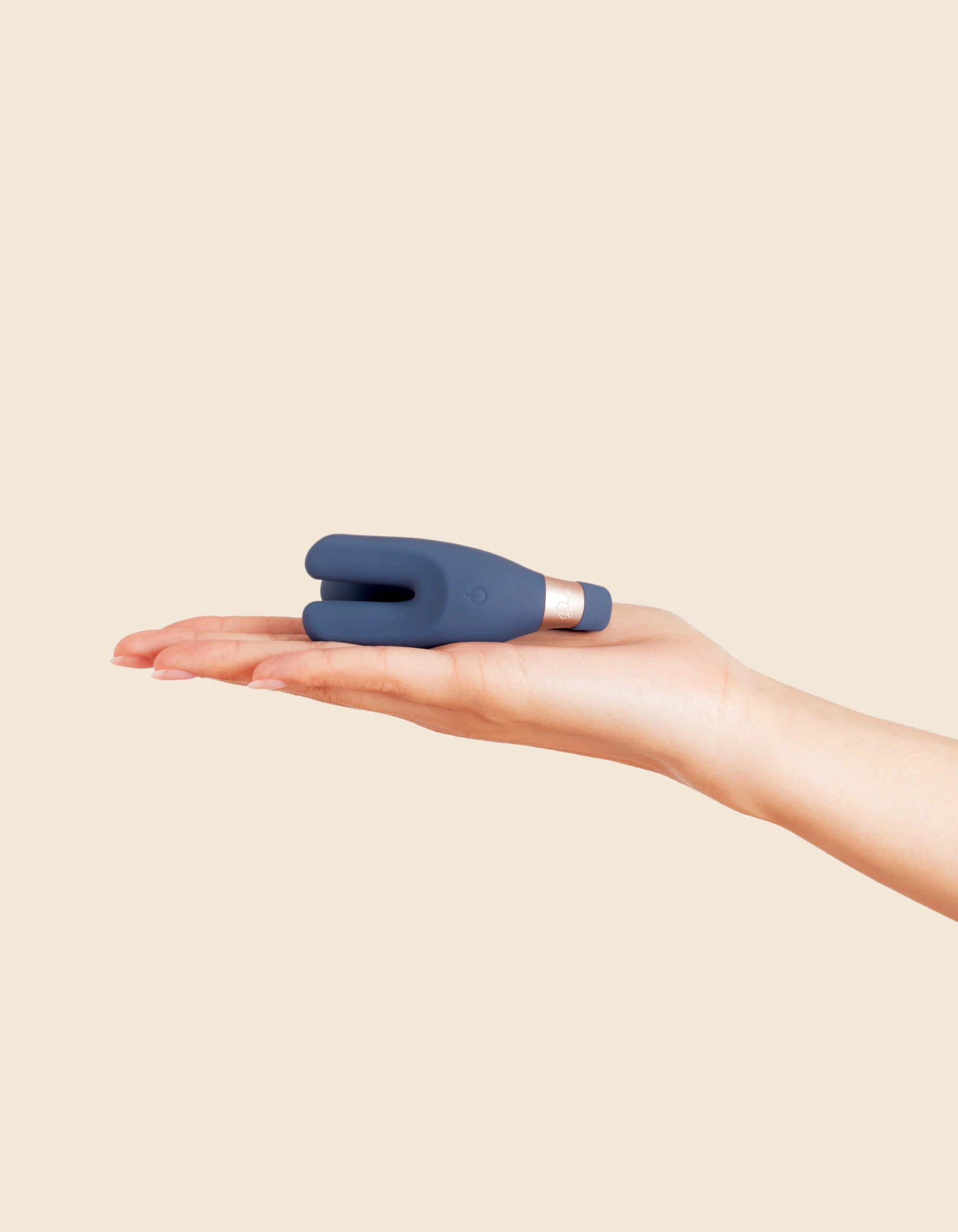 A blue wearable remote control vibrator rests on a person's palm.