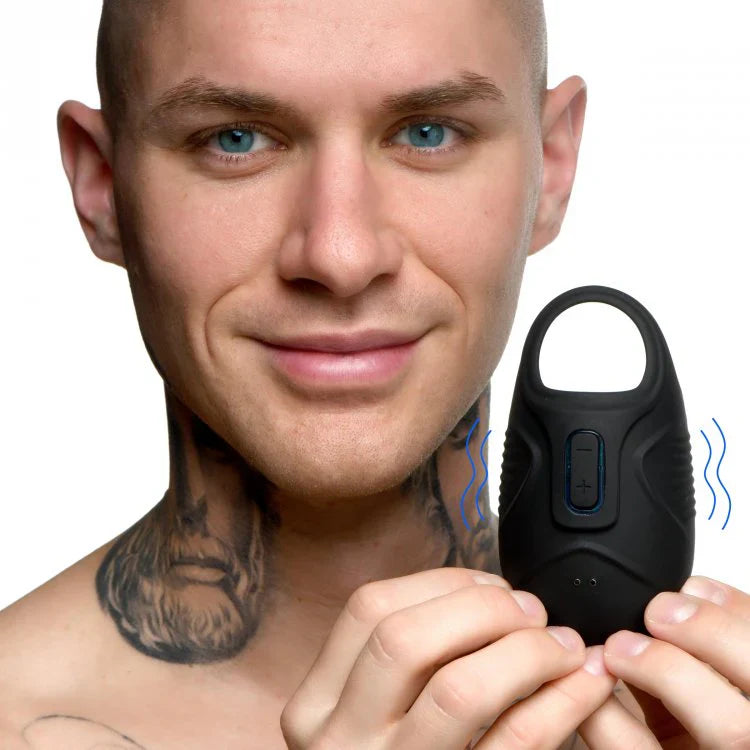 Man holding a black vibrating silicone ball sack with a loop.