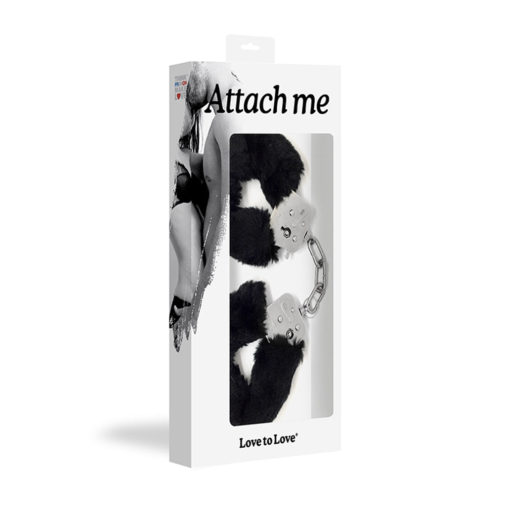 Black faux fur lined metal handcuffs on a white box.