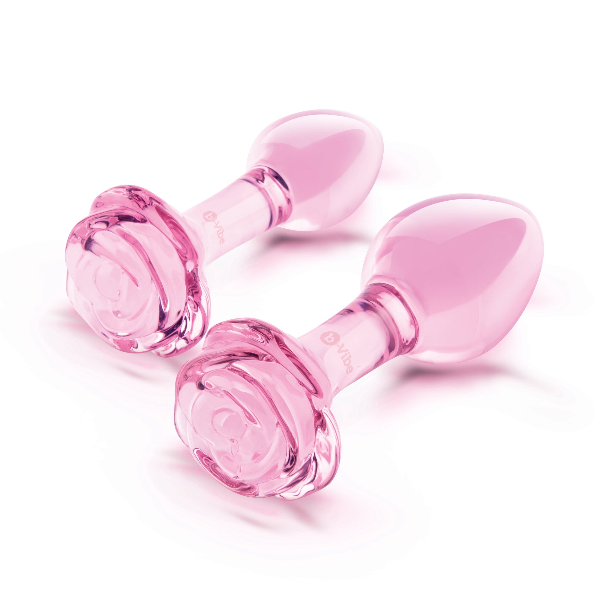 Two pink glass anal plugs with rose-shaped bases.