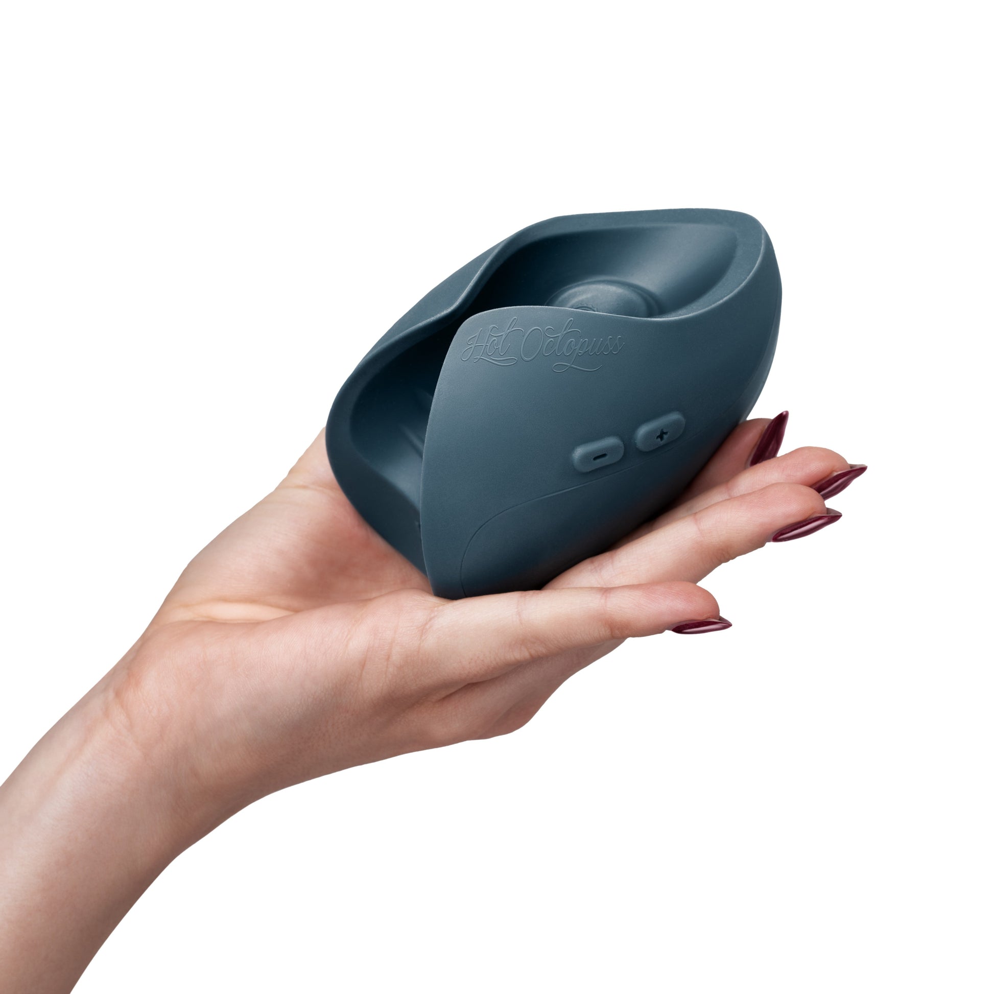 A hand holds a teal colored, curved vibrator with "Hot Octopuss" embossed on it.