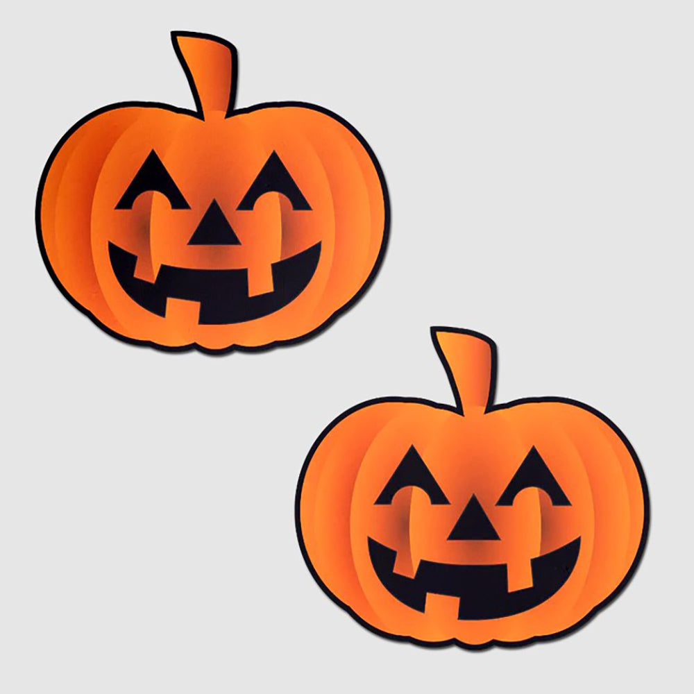 Two orange pumpkin jack o' lantern nipple pasties on a light gray background.