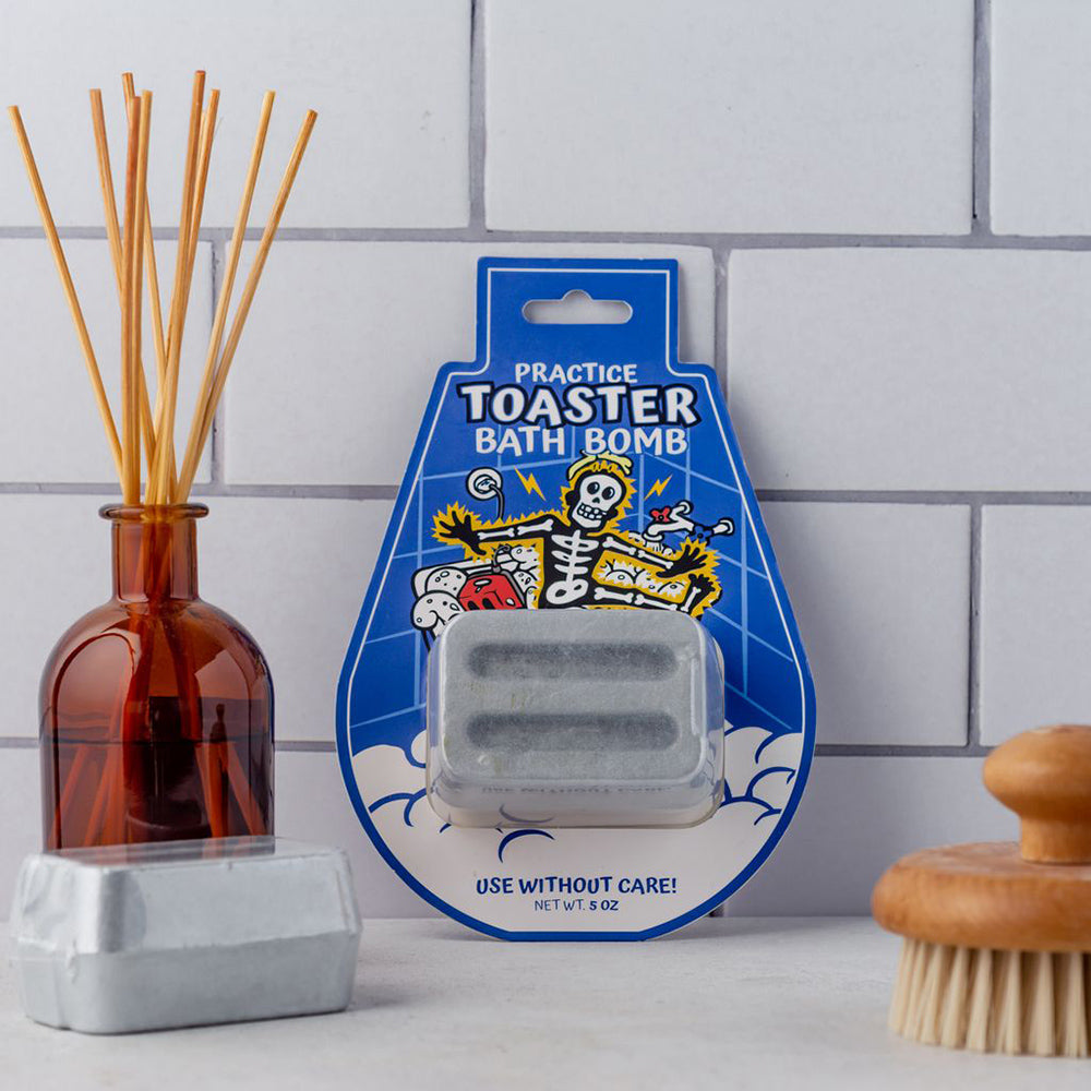 A toaster-shaped bath bomb in packaging with a skeleton graphic.