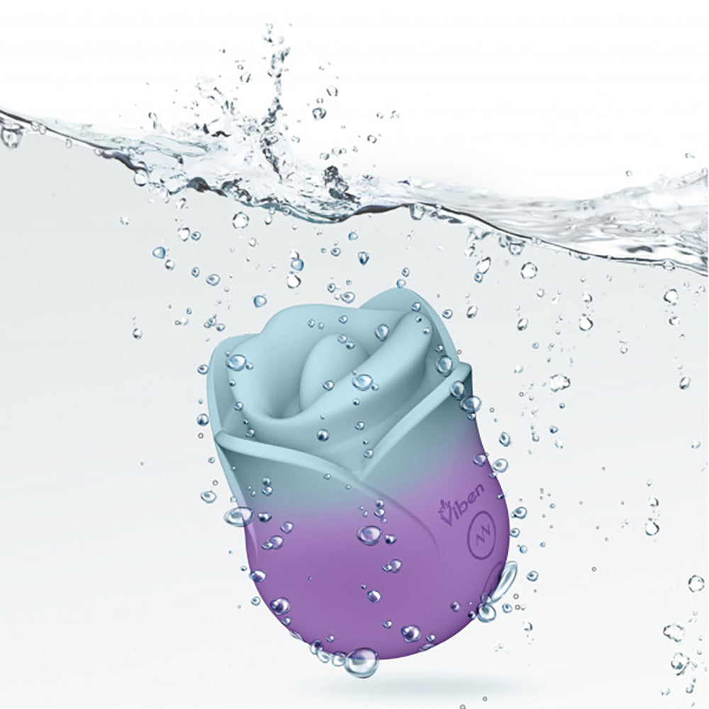 A rose-shaped clitoral stimulator in blue and purple, partially submerged in water.