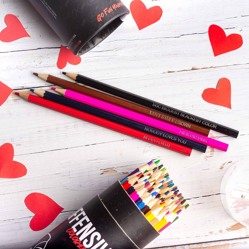 A set of 48 offensive colored pencils with humorous names on a wooden surface.
