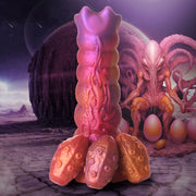 Pink and purple silicone dildo with textured base and alien creature.